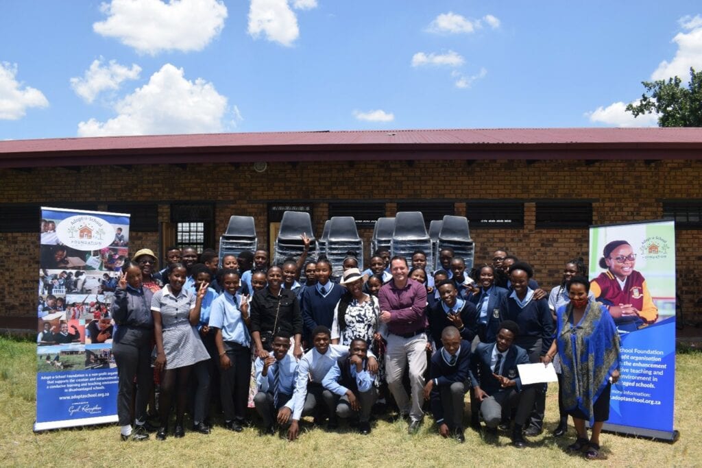 Learners at Dr Beyer’s Naude Secondary School in Dube, Soweto, receive school chairs.